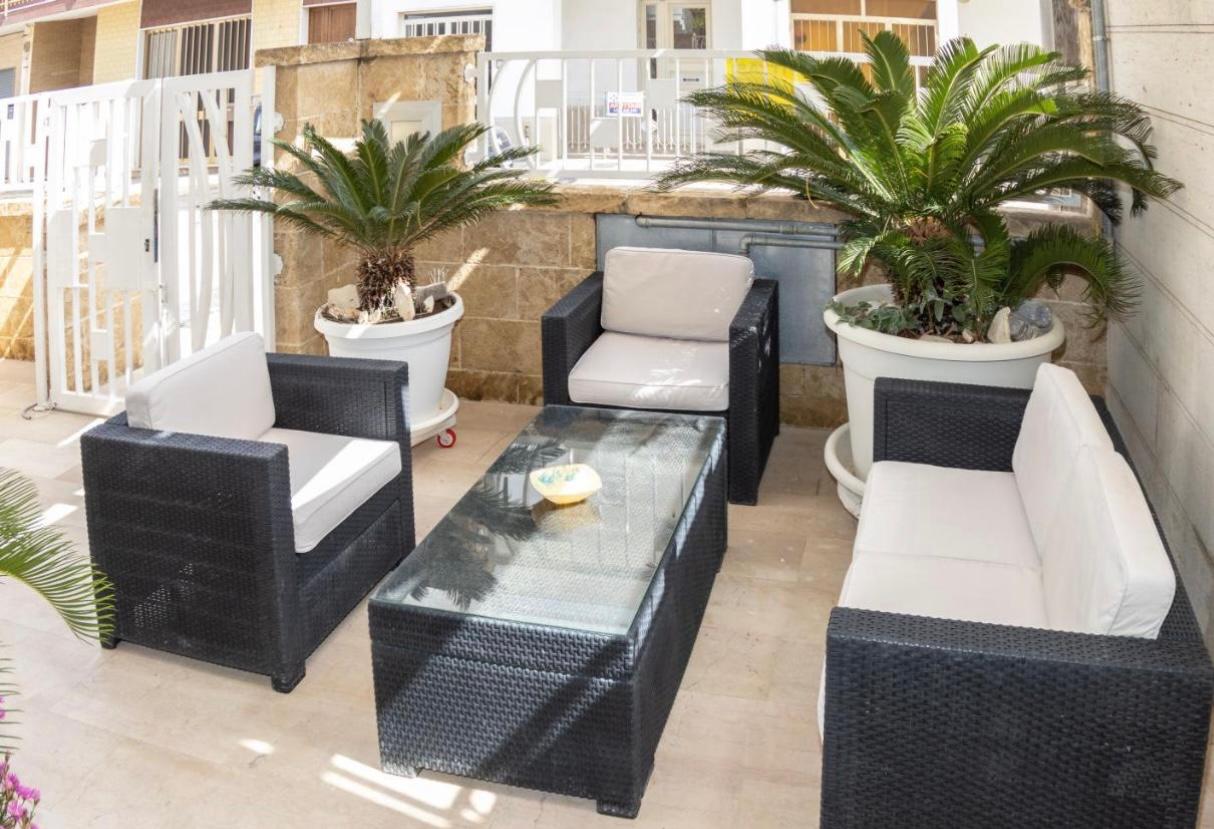 Patio Esterno - Salotto completo con cuscini bianchi e tavolo in vetro