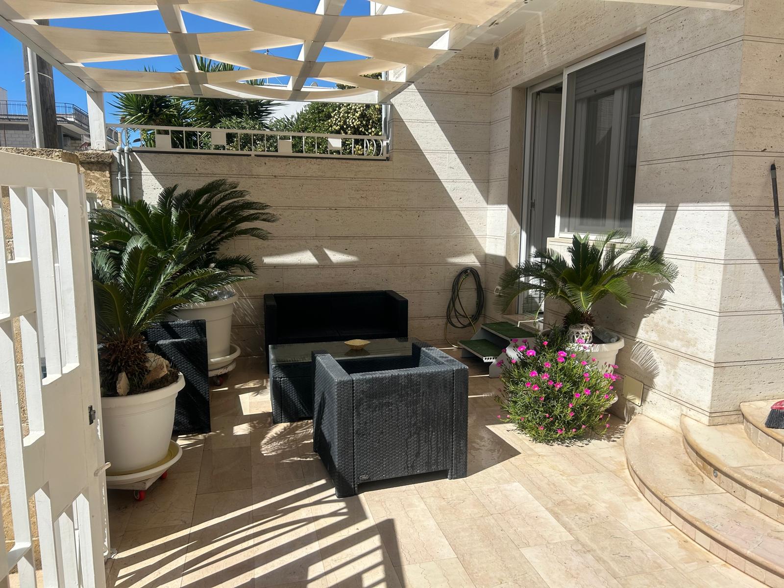 Patio Esterno - Salottino in rattan protetto da tenda a vela